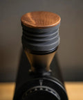 Killer Variable Speed Single Dose Coffee Grinder Equipped With 83mm Red Titanium Flat Burrs and a rock stable burr carrier in glossy black with wooden lid.