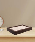 Sleek Wooden Jewelry Organizer Tray With 30 Compartments And A Sick Walnut Finish on a home desk next to a clock.
