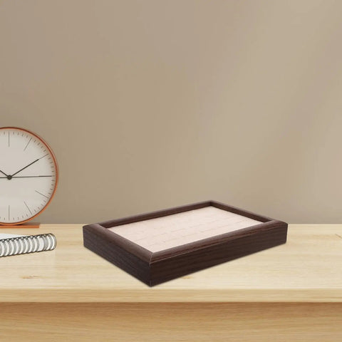 Sleek Wooden Jewelry Organizer Tray With 30 Compartments And A Sick Walnut Finish on a home desk next to a clock.