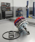 Heavy Duty Automotive Actuator Assembly With Glossy Red Cover And Precision Seals For Direct Swap Install Providing Rock Solid Drivetrain Control Built Tough For The Daily Street Grind on a metal surface with a coil spring.