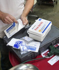 First Aid Kit, white rectangular container with red label, 10-person ANSI A kit with trauma pads and bandages