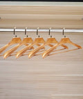 Heavy Duty Stainless Steel Clothes Rod For Modern Closets installed with wooden hangers, showing wall-mounted design