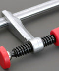 Heavy Duty Bench Dog Clamp With PP Handle, adjustable workbench stop, close-up of red handle on steel woodworking fixture