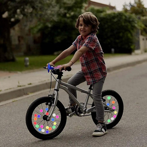 Child riding bicycle with Multicolor Bicycle Spoke Beads Set With Luminous Plastic Clips, vibrant spoke decoration on wheels.