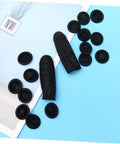 Heavy Duty 1000 Pack Finger Sleeve Protectors Soft Latex Tip Guards Sick Grip For Mechanics Factory Workers Guitar Shredders And Sewing Crew Lightweight Daily Grind Essential black latex fingertip guards scattered on blue background.