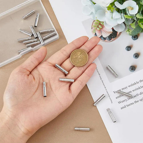60Pcs Bolo Tie Tips And Cap Buckles Set In Silver Tone, 21.5mm Long With 4mm Inner Diameter, Alloy Bolo Findings For DIY Jewelry Making, Garment Decoration And Craft Projects, Platinum Finish shown in hand with coin