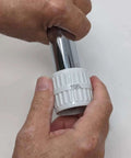 Stainless steel pipe reamer tool with white adjustable cap labeled TOFL, used on pipes