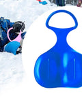 Child playing in snow with Snow Sled Toboggan for Kids and Adults, Cold-Resistant PP Build With Comfy Handles, Blue.
