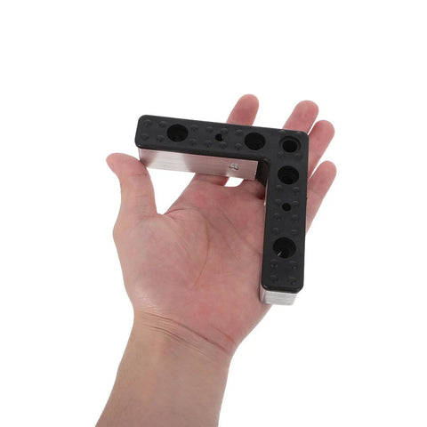 Close-up of a hand holding 4 Pack L Shaped Aluminum Furniture Legs With Plastic Bases For TV Stands And Woven Sofa Frames