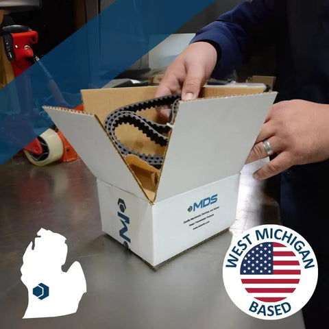 Person handling a box with contents labeled West Michigan Based, showcasing a product related to the region.