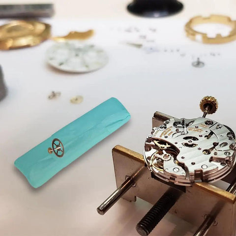 Timepiece Cleaning Putty For Watches Pro Grade Dry Clay Bar with watch movement parts on a workstation.