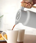 Pouring coffee from 50 Oz Thermal Coffee Carafe Stainless Steel Insulated Dispenser Keeps Your Brew Hot Or Cold For Hours in kitchen