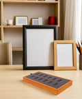 Slick Gray Solid Wood Jewelry Display Tray Featuring 12 Ring Slots Top Shelf Storage Organizer Box on a wooden table with frames.