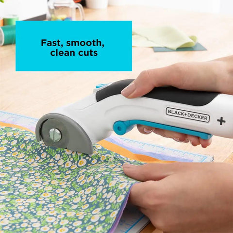 4V Max Cordless Fabric And Craft Cutter Rotary Tool with USB, self-sharpening blade cutting floral fabric, comfort grip in use.