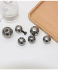 Six stainless steel M6 threaded piercing balls with drilled holes, silver.
