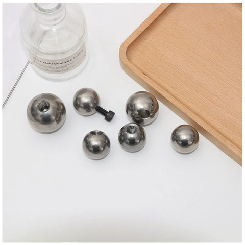 Six stainless steel M6 threaded piercing balls with drilled holes, silver.