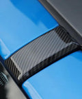 Close-up of Premium Carbon Fiber Windshield Screw Covers For Ford Bronco 2021 To 2023 left bezel on blue surface.