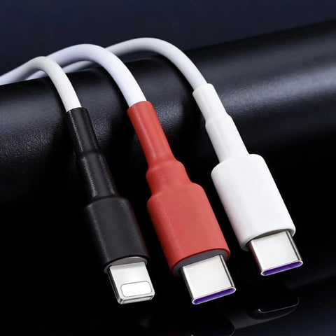 Three USB cables in black, red, and white on a black surface