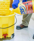 Top Shelf Heavy Duty Floor Cleaning Kit With Stripper Sealer Polish And Cleaner Four Gallon Set pouring floor stripper into yellow mop bucket.