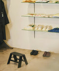 Ml10 1BK 1 Step Ladder Black With Folding Safety Bar in store setting, self-standing near shelves, grooved non-slip steps visible.