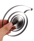 Hand holding coiled Two Piece Steel Clock Mainsprings Replacement Kit for mechanical clocks, universal fit, durable steel