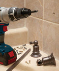 Bosch HDG12 1/2 in diamond hole saw mounted on a cordless drill beside tiled wall and plumbing fittings.