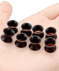 0G Black Silicone Ear Gauges Tunnels Plugs Set 8mm Ultra Thin Flexible Soft displayed on a hand