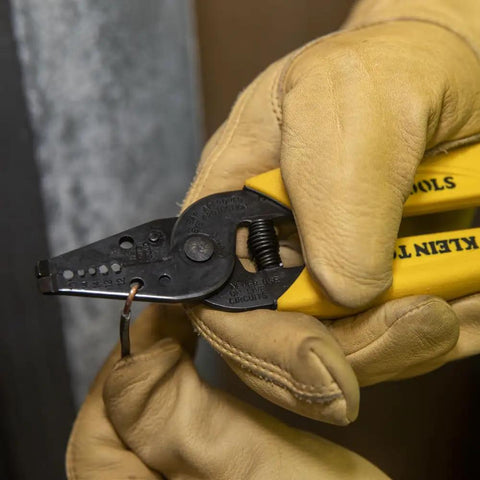 Built Tough Dual Wire Stripper Cutter For Solid Wire With 14 And 12 AWG Holes Plus 10 AWG Stripping Hole in worker's gloved hand