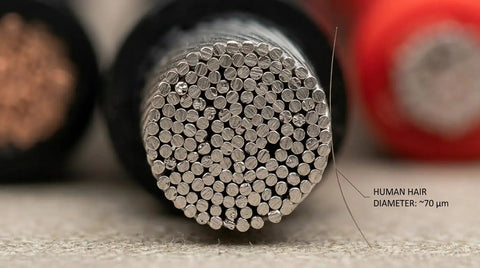 Close-up of 8 Gauge Silicone Wire 33ft Ultra Flexible 2 Conductor Parallel Cable With Tinned Copper strands next to human hair for scale.