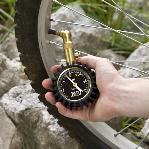 Close-up of JACO Elite low-pressure tire gauge with brass nozzle attached to a bicycle tire valve
