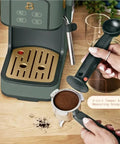 Rock Solid Compact Espresso Machine In Fresh Thyme Green with portafilter and 2-in-1 tamper on wooden counter.