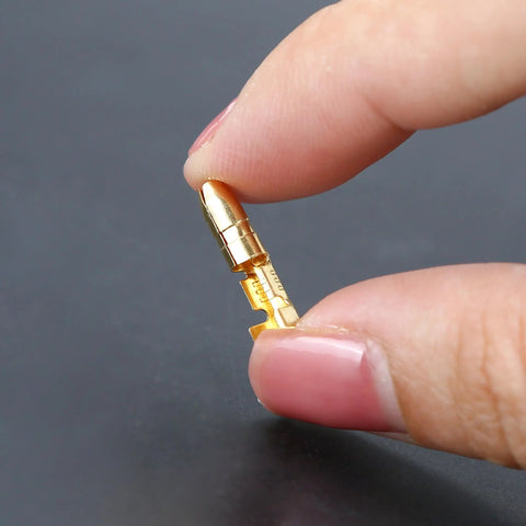 Close-up of a single gold tin-plated bullet connector from the 50 Pack Double Spade Wire Connectors For Motorcycle Wiring, 4mm size.
