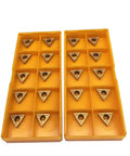 Front view of two yellow plastic organizers with 20 TCMT21.51 carbide turning inserts (triangular with center holes)