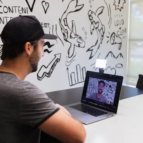 Person using a laptop with a Video Conference Lighting Kit for Zoom and live streaming attached, enhancing screen presence with adjustable lighting.