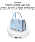 Depisuta 22cm Electric Rotating Turntable Display Stand With Led Colorful Light showcasing a blue handbag on a motorized platform.