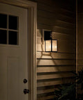 Lahden 16.75 Inch One Light Outdoor Wall Light With Clear Seeded Glass And Weathered Zinc Finish on house entryway at night