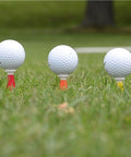 Flexible Fluorescent Golf Tees In Red Orange Yellow, 8 Pack, Assorted Sizes, holding golf balls on grass for smoother swing