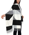 Black And White Piano Grid Winter Scarf Crafted From Plush Faux Cashmere With Extended Fringe Edges, worn elegantly with a hand out.