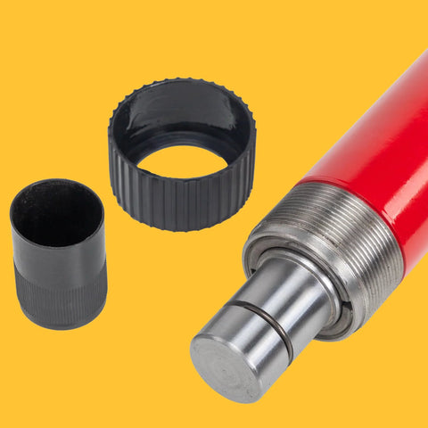 Close-up of a red hydraulic floor jack pump with metal piston and black and gray adapters.
