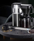 Heavy Duty Fully Automatic Espresso And Drip Coffee Maker With Digital Display Six Steam Nozzles For Killer Brews on black table with cup.