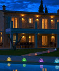 Color Changing Solar Powered Glass Ball Lights For Garden Patio And Indoor Decor along a walkway at dusk