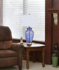28 Inch Sky Blue Hand Blown Glass Table Lamp with Ginger Jar Twist on a living room table, ambient daytime setting.