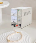 3A Electroplating Machine For Jewelry, 110V Pro Grade Gold And Silver Plating Power Supply with dials and jewelry on display.
