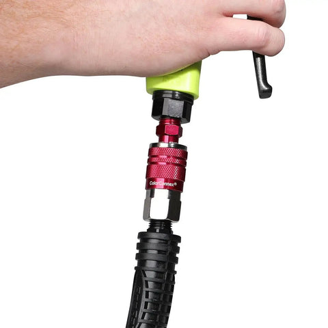 Hand holding Industrial Type D Red 14 Piece Coupler And Plug Kit With 1 Quarter Inch NPT Fittings For Heavy Duty Use.