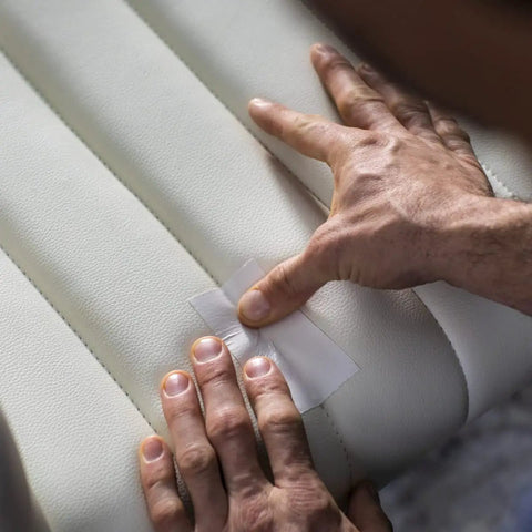 Applying Heavy Duty White Duct Tape 3 Pack 1.88 Inch By 30 Yard Rolls, 90 Yards Total, on a white leather surface for repair