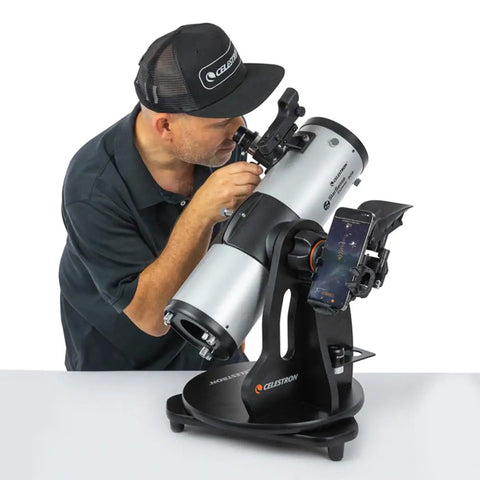 Man using StarSense Explorer 114AZ App Enabled Telescope for Beginners with Smartphone Dock and Sky Tour, 114mm Tabletop Dobsonian.