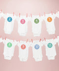 White onesies with month numbers hanging on a pink background, each marked 1-12 months; light t shirt transfers 8938 pack of 18 for white.