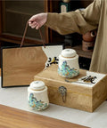 Vintage Airtight Ceramic Double Tea Canisters For Loose Leaf Coffee Beans And Spices on a wooden counter with a decorative box.