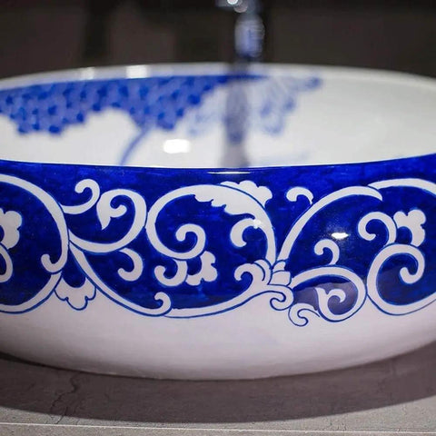 Slick Oval Vessel Sink For Bathroom Vanity Top Notch Premium Porcelain Countertop Wash Basin featuring hand painted blue floral motif.
