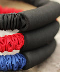 Close-up of red, blue, and black elastic bands showcasing Archery Bow Trainer Band For Draw Resistance And Strength Training, Adjustable 25 To 45 Lbs